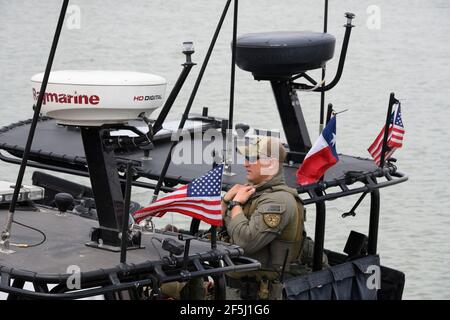 Granjeno, Texas, États-Unis, 26 mars 2021. Le trooper du ministère de la sécurité publique du Texas attend qu'un groupe de sénateurs républicains américains embarque à bord d'un canonneau spécialement équipé pour une promenade sur le fleuve Rio Grande au sud de Mission à la fin d'une tournée à tourbillon dans le sud du Texas. Les sénateurs ont vu un centre de traitement des migrants surpeuplé à Donna et un cadavre flottant dans la rivière au nord du parc Anzalduas. Crédit : Bob Daemmrich/Alay Live News Banque D'Images