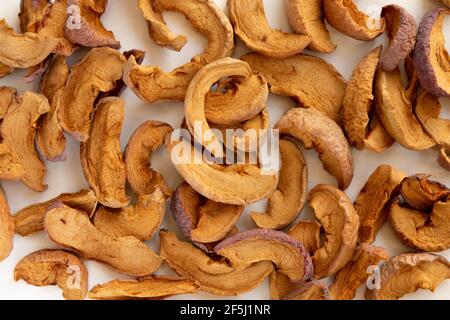 Tranches de fruits séchés au soleil pommes déshydratées sur fond blanc. Tranches de pommes séchées faites maison. Pose à plat. Banque D'Images