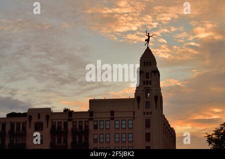 Chicago, Illinois, États-Unis. La statue située au-dessus de l'édifice administratif du complexe Montgomery Ward est illuminée par le soleil couchant. Banque D'Images