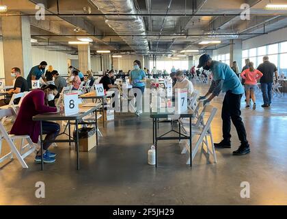 Frisco TX, Etats-Unis - 26 mars 2021 : vue intérieure des personnes portant un masque et remplissant le formulaire de vaccination COVID 19 Banque D'Images