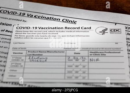 Bethesda, MD, Etats-Unis 03-22-2021: Une carte de vaccination COVID 19 sur un bureau en bois. La carte détaille la date, le type et le numéro de dose de l'administrateur Banque D'Images