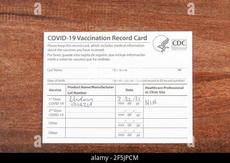 Bethesda, MD, Etats-Unis 03-22-2021: Une carte de vaccination COVID 19 sur un bureau en bois. La carte détaille la date, le type et le numéro de dose de l'administrateur Banque D'Images