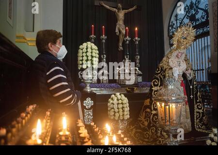 Une femme portant un masque facial se tient à côté des statues du Christ et de la Vierge comme elle montre son respect à l'Archiconfrérie de l'Expiracion pendant le vendredi du chagrin. Quelques jours de début de la semaine sainte espagnole marquée par une situation de stabilité des infections à coronavirus et la peur face à une nouvelle vague en Espagne, les fraternités ont décidé de célébrer une semaine sainte différente sans processions massives mais préparant diverses activités. Des expositions religieuses, des masses et des adorations ou l'occasion pour les croyants peuvent admirer les statues du Christ et de la Vierge Marie à l'intérieur des églises et des temples, sera une certaine e Banque D'Images