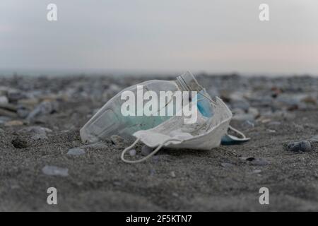 Pollution sur la plage, plastique y compris les bouteilles, masques chirurgicaux et autres déchets Banque D'Images