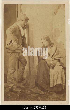 Homme avec chapeau rond debout à côté d'une femme assise avec bébé. Inconnu Banque D'Images