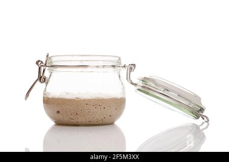 Levure maison de démarrage poussant dans un pot en verre isolé sur fond blanc. Démarreur levain. Banque D'Images