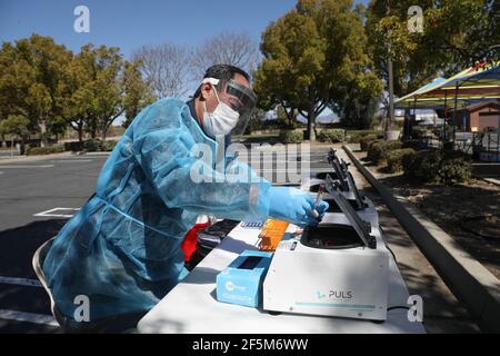 Chino Hills, Californie. 24 mars 2021. Un technicien retire les flacons d'échantillons de sang de la machine de traitement à centrifuger au GUARDaHEART Test d'anticorps COVID-19 sans frais qui se tient à l'église de Jésus-Christ des Saints des derniers jours à Chino Hills, en Californie. Crédit: Sheri Determan Banque D'Images