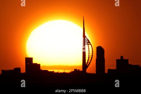 Portsmouth, Hampshire. 27 mars 2021. Météo Royaume-Uni. Lever de soleil sur la Tour Spinnaker et Portsmouth, vue de l'autre côté du Solent, lors d'une matinée ensoleillée et lumineuse avec des douches occasionnelles. Credit Stuart Martin/Alay Live News Banque D'Images