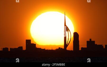 Portsmouth, Hampshire. 27 mars 2021. Météo Royaume-Uni. Lever de soleil sur la Tour Spinnaker et Portsmouth, vue de l'autre côté du Solent, lors d'une matinée ensoleillée et lumineuse avec des douches occasionnelles. Credit Stuart Martin/Alay Live News Banque D'Images