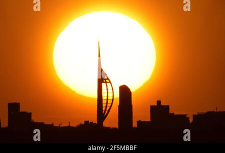 Portsmouth, Hampshire. 27 mars 2021. Météo Royaume-Uni. Lever de soleil sur la Tour Spinnaker et Portsmouth, vue de l'autre côté du Solent, lors d'une matinée ensoleillée et lumineuse avec des douches occasionnelles. Credit Stuart Martin/Alay Live News Banque D'Images