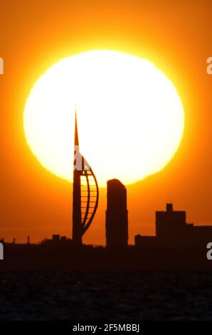 Portsmouth, Hampshire. 27 mars 2021. Météo Royaume-Uni. Lever de soleil sur la Tour Spinnaker et Portsmouth, vue de l'autre côté du Solent, lors d'une matinée ensoleillée et lumineuse avec des douches occasionnelles. Credit Stuart Martin/Alay Live News Banque D'Images