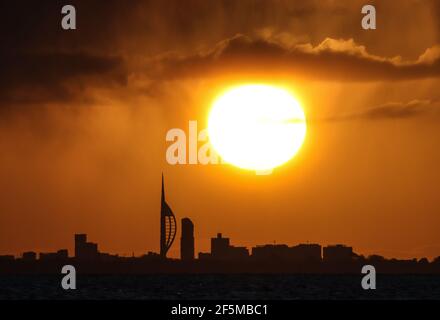 Portsmouth, Hampshire. 27 mars 2021. Météo Royaume-Uni. Lever de soleil sur la Tour Spinnaker et Portsmouth, vue de l'autre côté du Solent, lors d'une matinée ensoleillée et lumineuse avec des douches occasionnelles. Credit Stuart Martin/Alay Live News Banque D'Images