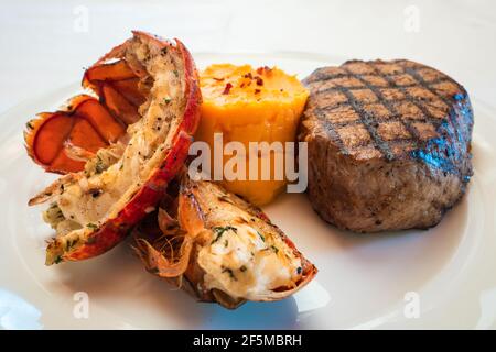 Steak de filet de surf et de gazon et queue de homard grillées Une assiette blanche avec purée de pommes de terre douce Banque D'Images