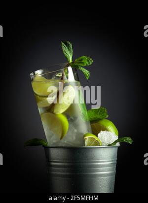 Mojito cocktail avec glace, citron vert et menthe dans un seau en métal avec glace. Banque D'Images