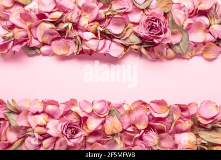 Composition des fleurs. Cadre fait de fleurs de rose séchées, de pétales et de feuilles. Vue de dessus avec espace de copie. Banque D'Images