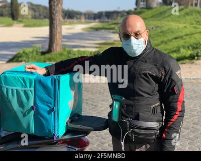 Rome, Italie. 25 mars 2021. Antonello Badessi, pilote de livraison de nourriture, pose pour une photo au Circus Maximus à Rome, Italie, le 25 mars 2021. La pandémie du coronavirus a déclenché un boom pour les entreprises offrant des services de livraison de nourriture. Toutefois, Antonello Badessi, l'un des plus longs pilotes de livraison de nourriture en activité à Rome, a déclaré que la plupart des avantages n'ont pas été répercutés sur ceux qui font des livraisons. POUR ALLER AVEC "Feature: Livraison alimentaire rider à Rome dit que son industrie change plus rapidement en raison de la pandémie" crédit: STR/Xinhua/Alamy Live News Banque D'Images