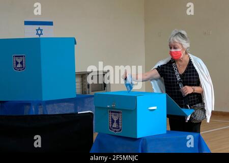 Une israélienne portant un masque de protection contre la pandémie de COVID-19 a voté dans un bureau de vote alors que les Israéliens se dirigent vers les urnes le 23 mars 2021, à Jérusalem, en Israël. Les Israéliens votent aujourd'hui lors de la quatrième élection générale du pays en moins de deux ans. Les sondages d’opinion prévoient une course serrée entre ceux qui soutiennent le Premier ministre israélien le plus longtemps au pouvoir et ceux qui veulent qu’il ne soit plus au pouvoir. Banque D'Images