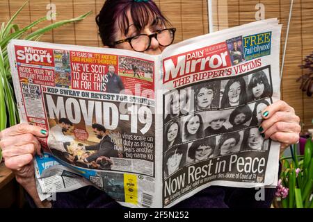 Lady lisant le journal Daily Mirror avec le titre le Rippers victimes Banque D'Images