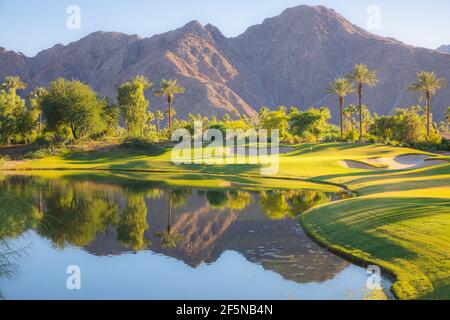 Magnifique lumière dorée sur Indian Wells Golf Resort, un parcours de golf dans le désert à Palm Springs, Californie, États-Unis avec vue sur les montagnes de San Bernadino. Banque D'Images