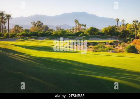 Magnifique lumière dorée sur Indian Wells Golf Resort, un parcours de golf dans le désert à Palm Springs, Californie, États-Unis avec vue sur les montagnes de San Bernadino. Banque D'Images