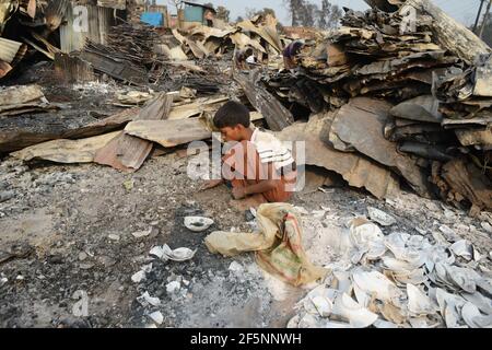 Un enfant recherchant ses effets sur un site de Des abris temporaires ont été mis en place pour les réfugiés déplacés de Rohingya quelques jours plus tard Un incendie dans un camp de réfugiés à Ukhi Banque D'Images