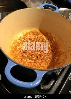 Solides de lait brunis laissés dans la casserole après avoir fait du beurre indien de ghee à utiliser dans la cuisine. Banque D'Images
