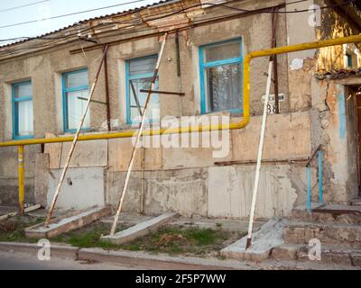 Feodosiya, Crimée - 15 septembre 2020 : supports de tuyaux soutenant la façade d'une ancienne maison Banque D'Images