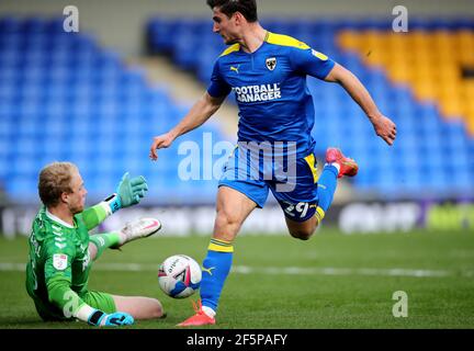 Ryan Longman (à droite), de l'AFC Wimbledon, a enregistré son tir par le gardien de but de Northampton, Jonathan Mitchell, lors du match Sky Bet League One à Plough Lane, Londres. Date de la photo: Samedi 27 mars 2021. Banque D'Images