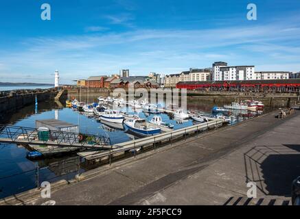 Newhaven Habour à l'extrémité ouest de Western Harbour Leith Arrime Édimbourg Écosse avec phare à l'entrée du port et bateaux amarrés à marée haute Banque D'Images