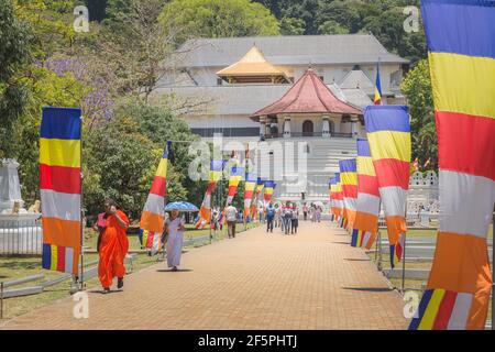 Kandy, Sri Lanka - Mars 20 2019: Touristes, locaux et drapeaux bouddhistes devant l'entrée principale de Dalada Maligawa menant au Temple de la dent sacrée Banque D'Images