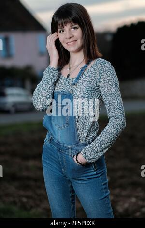 Portrait extérieur d'une jeune femme portant des salopettes la campagne Banque D'Images