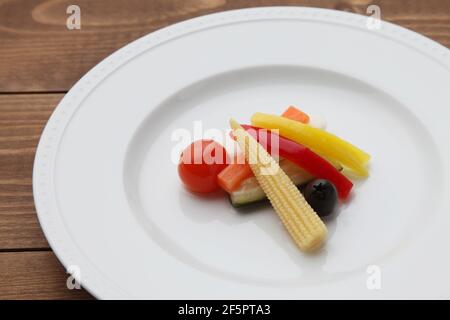 marinés salade de légumes marinés sur une assiette isolée sur une table en bois Banque D'Images