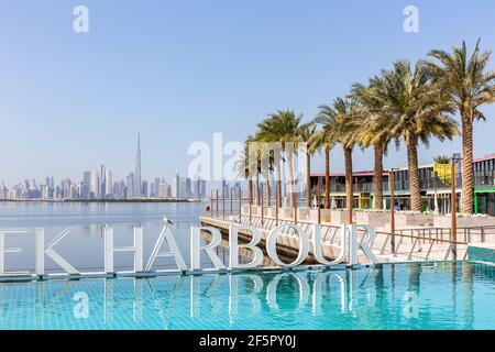 Dubaï, Émirats arabes Unis, 22.02.2021. Le port de Dubai Creek est entouré d'une piscine d'eau turquoise avec des rangées de palmiers et un horizon du centre-ville de Dubaï en arrière-plan. Banque D'Images