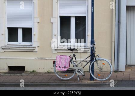 Vélo appuyé sur un feu de route contre le fond de un bâtiment Banque D'Images