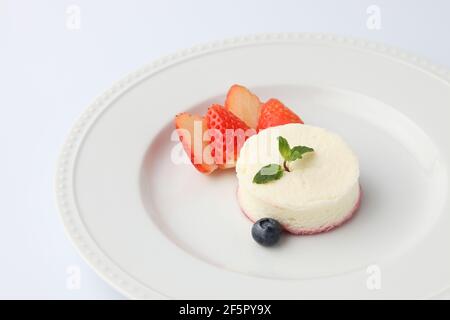 cheesecake blanc en mousseline sur plaque isolée sur fond blanc Banque D'Images