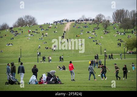 Londres, Royaume-Uni. 27 mars 2021. Météo au Royaume-Uni : les habitants de Primrose Hill profitent du soleil printanier avant que les restrictions de confinement ne soient légèrement assouplies par le gouvernement britannique le 29 mars. Les prévisions portent sur des températures beaucoup plus chaudes les 29 et 30 mars, alors que les températures devraient dépasser 20 °C. Credit: Stephen Chung / Alamy Live News Banque D'Images