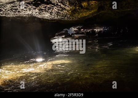 Spectaculaire Mermaid Caves avec lumière du soleil traversant le trou dans les roches volcaniques dans la piscine d'eau dans la grotte, à Nanakuli Beach Park, Oahu, Hawaii, Etats-Unis Banque D'Images