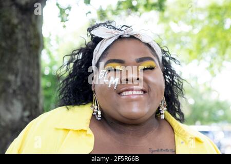 Belle, heureuse Afro-américaine fille souriant avec BLM sur joue et portant jaune Banque D'Images