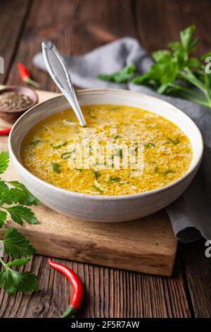 Soupe épicée rapide et simple aux œufs avec persil et chili sur fond de bois rustique Banque D'Images