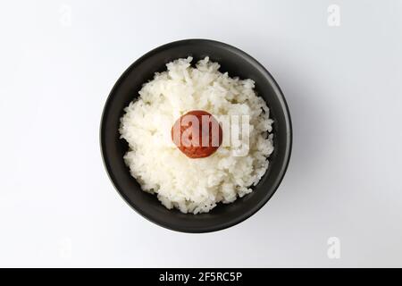 riz blanc ordinaire avec prune marinée dans un bol de baguettes isolé sur fond blanc Banque D'Images
