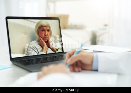 Une vieille femme malade qui parle avec un médecin par appel vidéo Banque D'Images