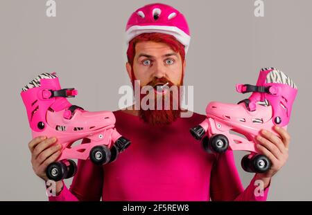 Casque Man in Sport avec patins à roulettes et sucettes. Homme barbu avec patins à roulettes. Vacances. Un mode de vie sain. Banque D'Images