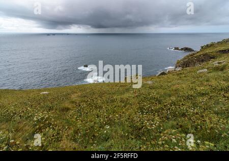 Un jour pluvieux et orageux avec vue sur l'Atlantique en direction du phare de Longships depuis la fin de Land à Cornwall, en Angleterre. Banque D'Images