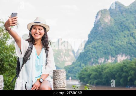 Femme prenant le selfie tout en explorant le paysage autour de Yangshuo Banque D'Images