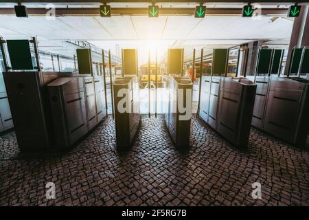 La rangée de tourniquets sur la pierre de pavage avec verre fermé portes et flèches vertes au-dessus permettant le passage à un moderne gare de dépôt avec Banque D'Images