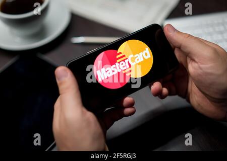 New York, New York / Etats-Unis - 11 11 2019: Logo de Mastercard sur l'iPhone X dans les mains au bureau Banque D'Images