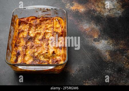 Cuisine italienne. Ensemble de lasagnes chaudes et savoureuses, sur plaque de cuisson, sur fond rustique sombre et ancien, avec espace pour le texte Banque D'Images