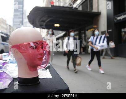 New York, États-Unis. 27 mars 2021. Les piétons portent des masques de visage lorsqu'ils marchent à côté d'une exposition de boucliers de visage pour la vente à New York City le samedi 27 mars 2021. Photo de John Angelillo/UPI crédit: UPI/Alay Live News Banque D'Images