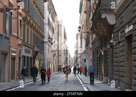 Rome, Italie. 27 mars 2021. Des personnes portant des masques de visage marchent sur la via dei Condotti à Rome, Italie, le 27 mars 2021. Selon les dernières données du ministère de la Santé, 23,839 nouveaux cas ont été enregistrés quotidiennement, ce qui a porté le total du pays à 3,512,453, comprenant des infections actives, des reprises et des décès, depuis que la pandémie a officiellement éclaté ici à la fin de février de l'année dernière. Credit: Cheng Tingting/Xinhua/Alay Live News Banque D'Images