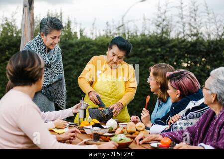 Grand-mère latine et petite-fille, fille qui cuisine la nourriture mexicaine à la maison, trois générations de femmes au Mexique Banque D'Images